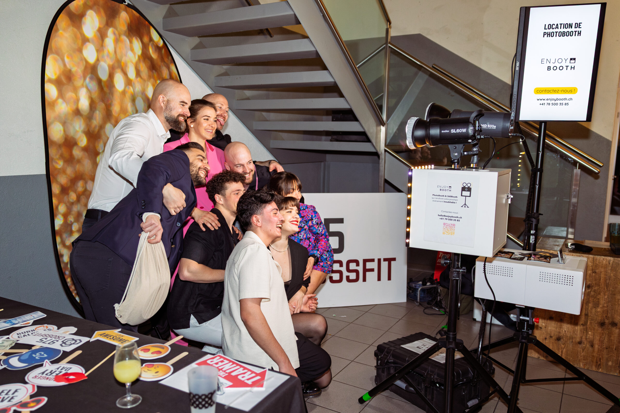 Photo de groupe souriant devant un photobooth lors d’un événement d’entreprise au Landeron, Neuchâtel.
