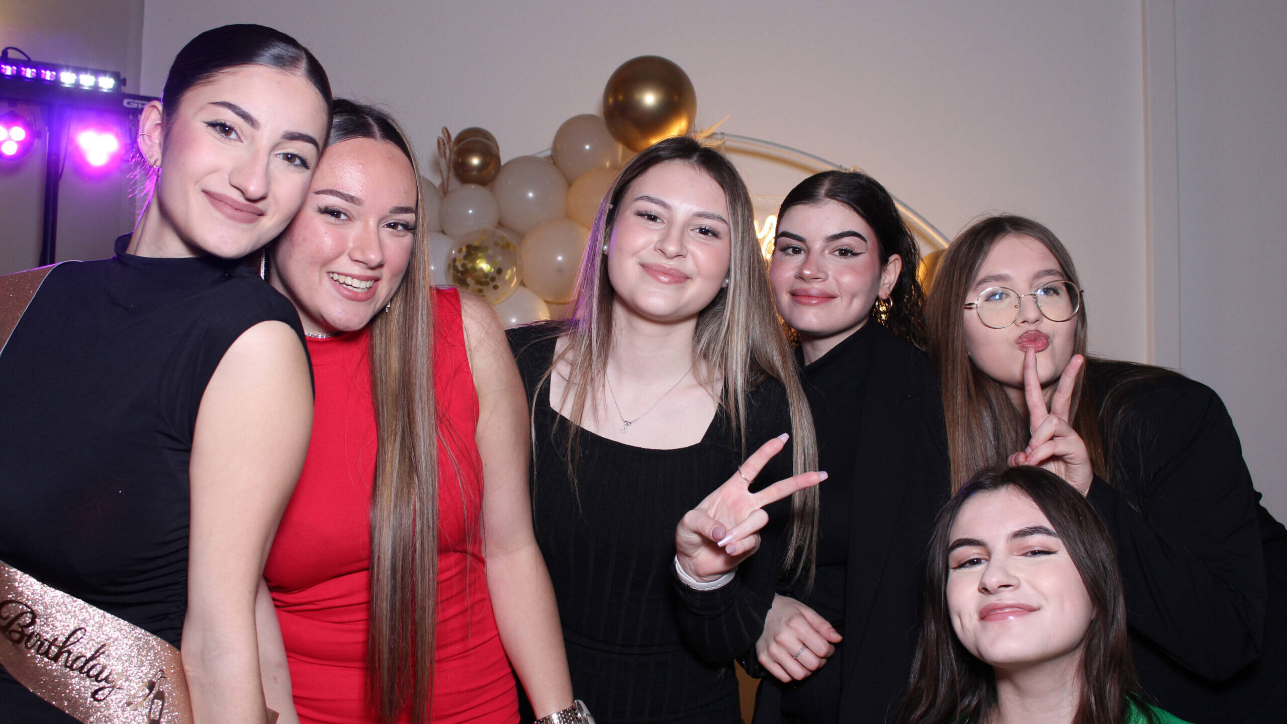 Groupe de jeunes filles posant devant un photobooth EnjoyBooth décoré pour un anniversaire à Lausanne